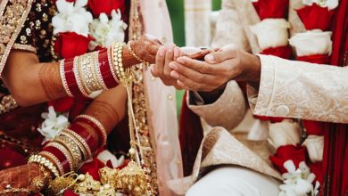 Hands of an Indian bride and groom intertwined for a wedding ritual.